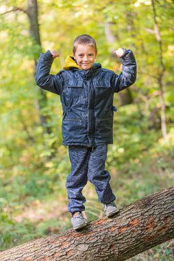 Ormanda kameraya gülümseyen bir çocuğun portresi..