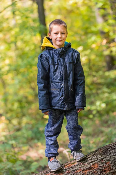 Ormanda kameraya gülümseyen bir çocuğun portresi..