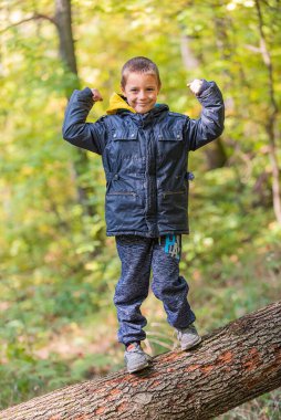 Ormanda kameraya gülümseyen bir çocuğun portresi..