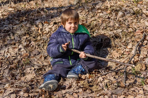Chłopiec Leży Lesie Liściu Mały Chłopiec Żółtymi Jesiennymi Liśćmi Parku — Zdjęcie stockowe