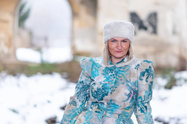 Terk edilmiş bir kalede kış kraliçesi. Kış elbisesi içinde güzel bir kadın.