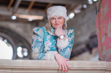 Kışlık paltolu ve kışlık şapkalı (Ushanka) güzel bir kadın. Terk edilmiş bir kalede güzel bir kadın..