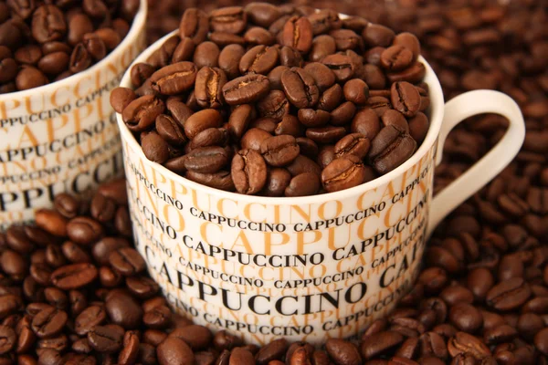 Bir kapuçino fincan kahve çekirdekleri — Stok fotoğraf