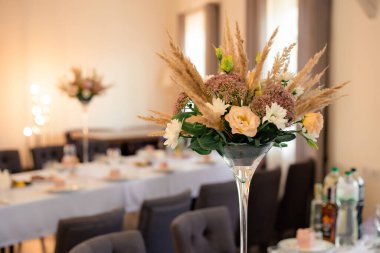 Düğün masası dekoru, dekoratif buketli vazo.