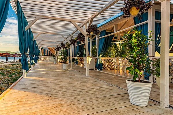 summer covered wooden terrace, with separate gazebos for relaxing on the beach