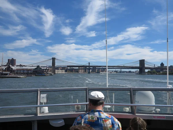 Facet w koszula hawajska patrząc w kierunku mostów w Nowym Jorku, podczas gdy na pokładzie łodzi jet silverstreak — Zdjęcie stockowe