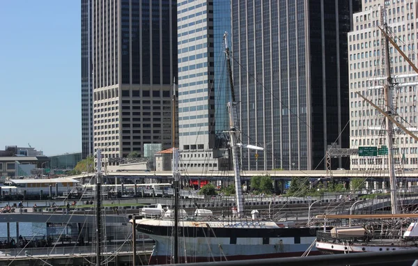 Vue du Wavertree Ship et d'autres navires contre les immeubles de bureaux du Lower Manhattan depuis le port de South Street à New York — Photo