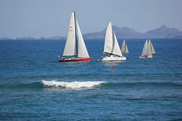 Jachtu nebo heineken regatta veslařský závod v st. martin s st. barth v pozadí — Stock fotografie
