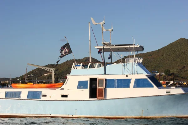 Torn Pirate Flag on Neglected Boat with Aqua Paint trim at Simpson Bay in St. Martin — Stock Photo, Image