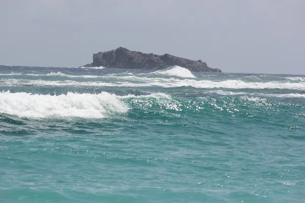 Seascape fale i błękitne niebo i Morze Karaibskie z cajon rock od brzegu plaży dawn beach w st. martin — Zdjęcie stockowe