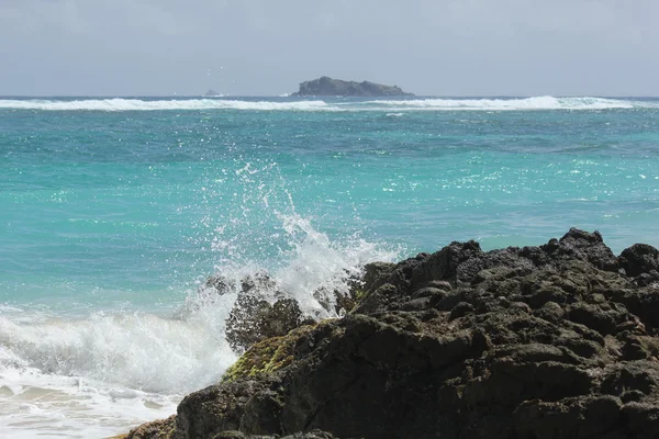 Seascape of waves and blue skies and caribbean sea with Cajon Rock offshore of Dawn Beach in St. Martin — Stock Photo, Image