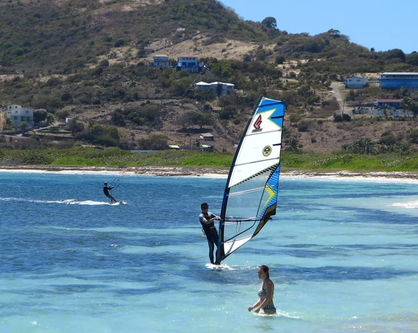 Wind surfing and swimming along one of the many fresh side beaches in St. Maarten — Stock Photo, Image