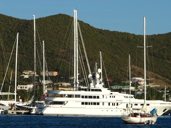 Mega Yates se sientan ociosos en Simpson Bay en St. Maarten en un hermoso día de cielo azul — Foto de Stock