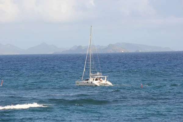 Mojito katamaran lub jacht na piękne błękitne wody z st. barth w oddali — Zdjęcie stockowe
