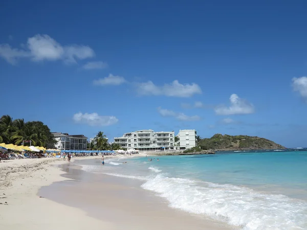 Wellen des Atlantiks krachen über das alte Korallenriff und Felsen am Morgenstrand, St. Maarten mit Austernbucht im Hintergrund — Stockfoto