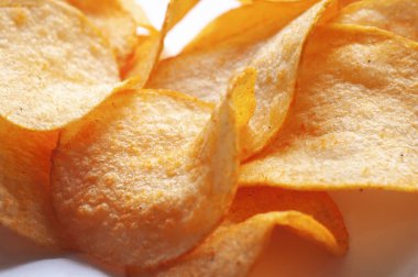 Beyaz arka planda gevrek ve lezzetli patates cipsi.