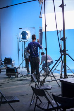 Stüdyodaki ışıklandırma mühendisi sahnenin ışıklarını ayarlıyor.