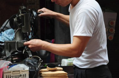 Yol kenarı ayakkabı tamircisi deri ayakkabıları tamir ediyor.