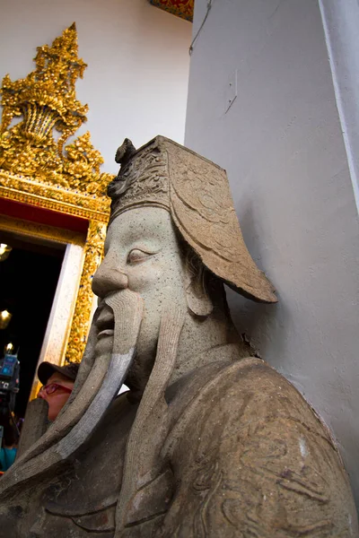 The stone statues in front of the temple gate are carved with Chinese style Shi Zhongweng in Zheng Wang Temple, Bangkok, Thailand