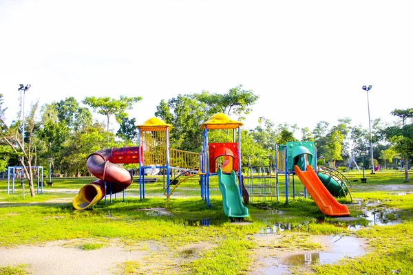 Parque infantil en la hierba cerca de la escuela es niños —  Fotos de Stock