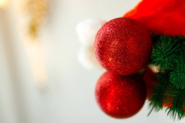Yeni yıl ve Noel geçmişi. Kırmızı şapka veya noel baba şapkası, bir Noel ağacı oyuncak topu ve ayna yüzeyine bir yapay ladin dalı yansıtılır. Metin veya ürün için yer, kopyalama alanı