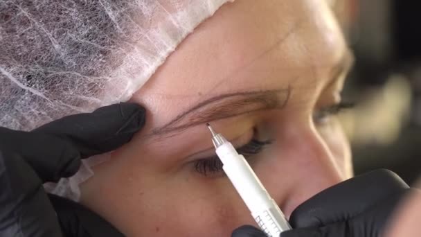 Close up make-up kunstenaar maakt potlood merken voor de procedure van permanente make-up. — Stockvideo