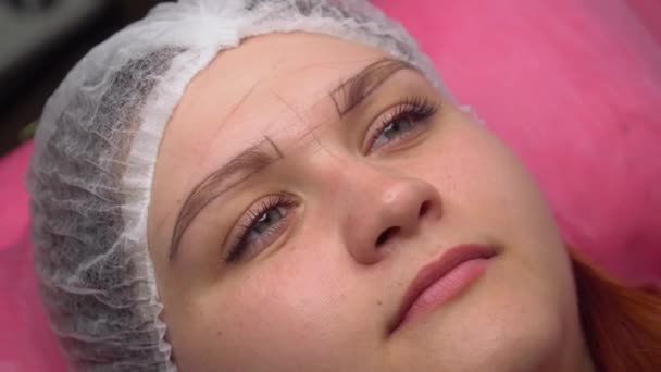 Portrait of a European woman with marked eyebrows before the permanent makeup procedure — стокове відео