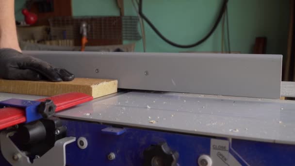 Ο ξυλουργός δουλεύει στη μηχανή πλάνισης στο οικιακό εργαστήριο. Επεξεργασία ξύλου — Αρχείο Βίντεο