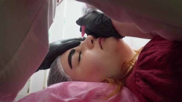 Proces nanášení permanentního make-upu tetování hnědé na obočí ženy v kosmetickém salonu — Stock video