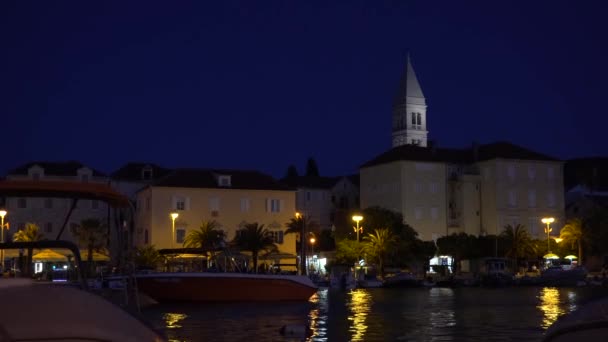 Vista desde el paseo marítimo de la Iglesia de San Pedro por la noche en la ciudad de Supetar en Croacia - 4K, Audio — Vídeos de Stock