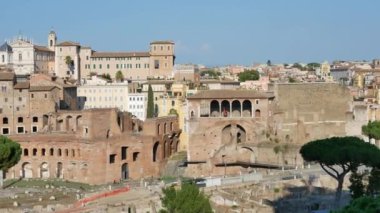 Roma 'da günbatımında antik binalara, yeşil çam ağaçlarına ve kolezyuma bakın - 4K, Pan