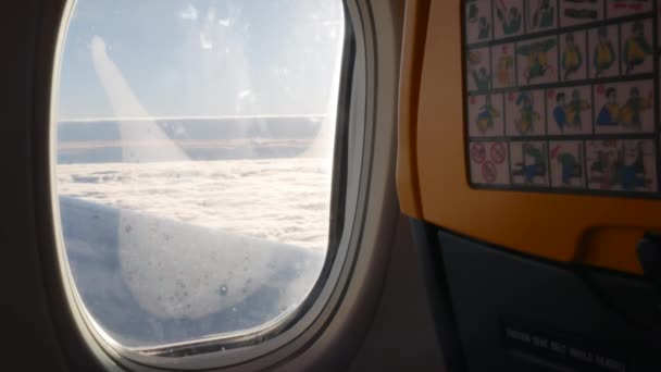 Sunny airplane window and seatback with safety instructions pictures - 4K, Editorial, Handheld — Stockvideo