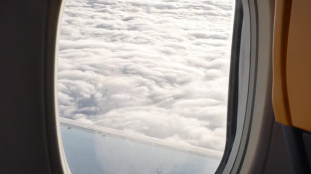 손으로 들고 태양이 비추는 구름 위에서 바라본 비행기 창문의 광경 - 4K — 비디오