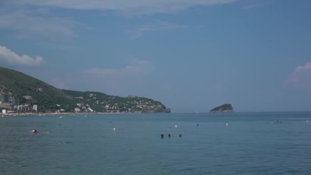 Menschen schwimmen in Strandnähe, umgeben von grünen Hügeln in Ligurien in Italien - Pan, Handheld, Audio — Stockvideo