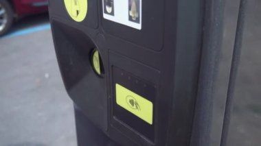 Woman inserts coins into the parking meter - Handheld, 4K, Editorial