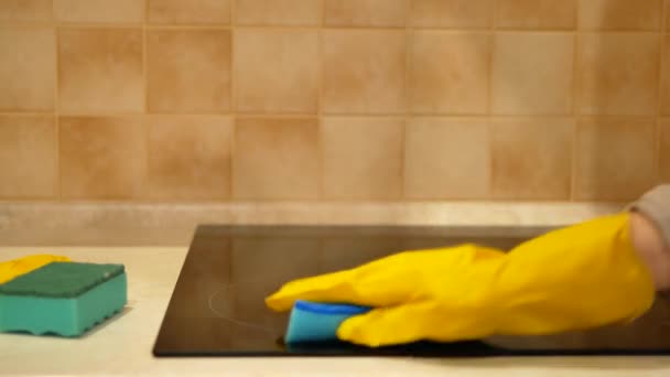 Woman hand in yellow glove carefully cleans induction cooker with blue cleaning sponge - 4K, Close up — Stock Video