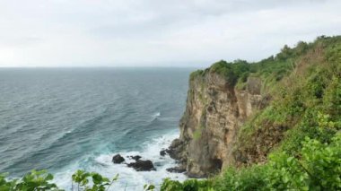 Güzel yeşil Uluwatu tapınağı uçurumu ve Hint Okyanusu 'nun turkuaz suyu, Bali - 4K