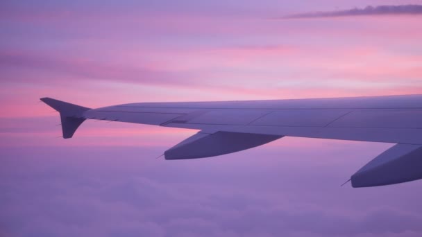 Vliegtuigvleugel boven de wolken bij prachtige zonsondergang - 4K — Stockvideo