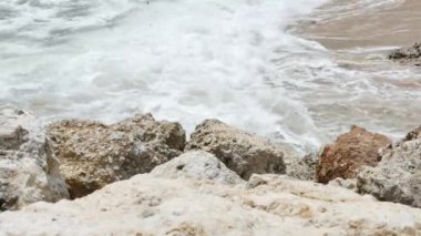 Ön planda kayalar ve Pandawa Sahili yakınlarında Hint Okyanusu dalgaları, Bali - 4K