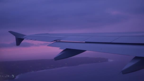 Utsikt från belysningsarmaturen på flygplansvingen över vattnet vid solnedgången - 4K, Få höjd, Handhållen — Stockvideo