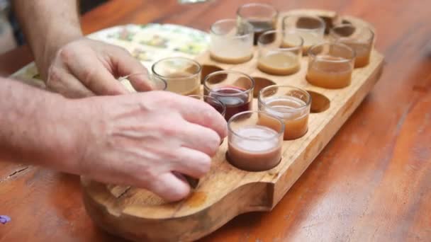 Vista de perto dos turistas mãos e bandeja com várias bebidas de café e chá na fazenda kopi luwak durante o degustação, Bali - 4K, Handheld — Vídeo de Stock