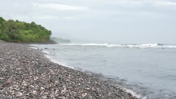 Pantai berbatu yang indah di pagi hari, pohon hijau dan gelombang laut di Amed, Bali - 4K, Audio, Handheld — Stok Video