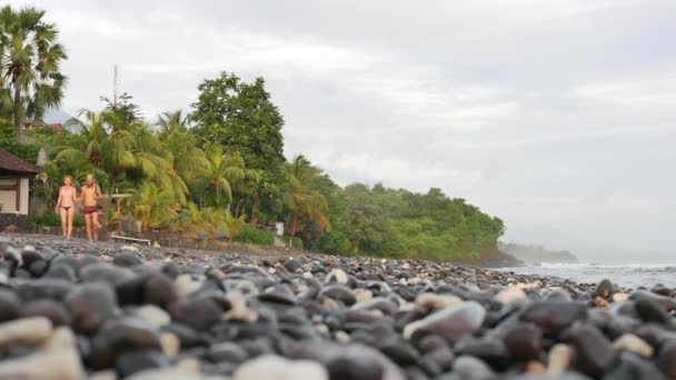 カップルがバリ島のAmedのペブルビーチで日の出に歩く- 4K 、編集、超ワイドショット — ストック動画