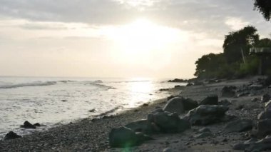 Amed, Bali 'deki volkanik kayalık sahilde güzel bir gün doğumu - 4K, Audio, Hand-held