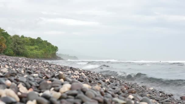 Krásná oblázková pláž to ráno, zelené stromy a mořské vlny v Amed, Bali - 4K, Audio, kapesní, mělká hloubka pole — Stock video