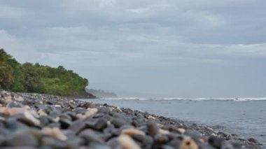 Bulutlu bir sabah sahili, yeşil tropikal ağaçlar ve Amed, Bali 'deki okyanus dalgaları - 4K, Saha Sığ Derinliği, Düşük açı