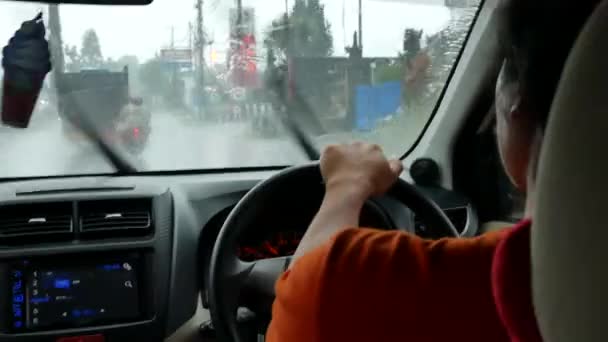 Widok wewnątrz samochodu na lokalnego kierowcę i drogi w ulewnym deszczu na Bali - 4K, Redakcja, Audio, POV, Średni strzał — Wideo stockowe