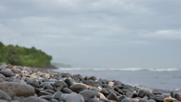 Pebbled beach on sunrise and blurred oceanic waves in Amed, Bali - 4K, Shallow Depth of Field, Low angle, Audio — Video