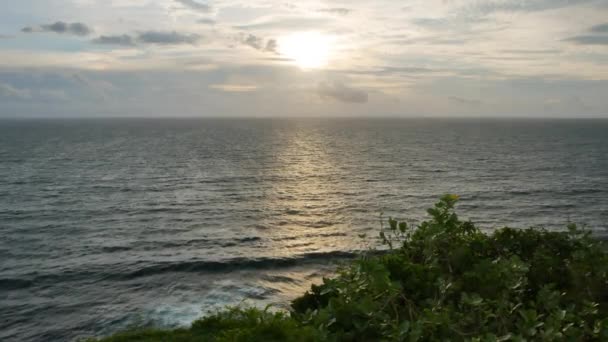 前景のインド洋と緑の植物、ウルワツ寺院、バリ- 4K 、ワイドショットでの景色のリラックスした夕日 — ストック動画