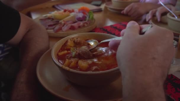 El hombre come sopa tradicional de bogracs húngaros con carne en Heviz, Hungría - FHD, Handheld — Vídeo de stock